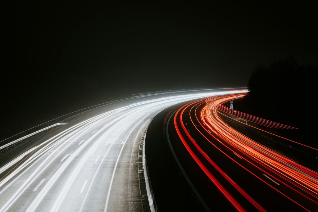 Picture of a road at night taken with long exposure showing light trails from cars